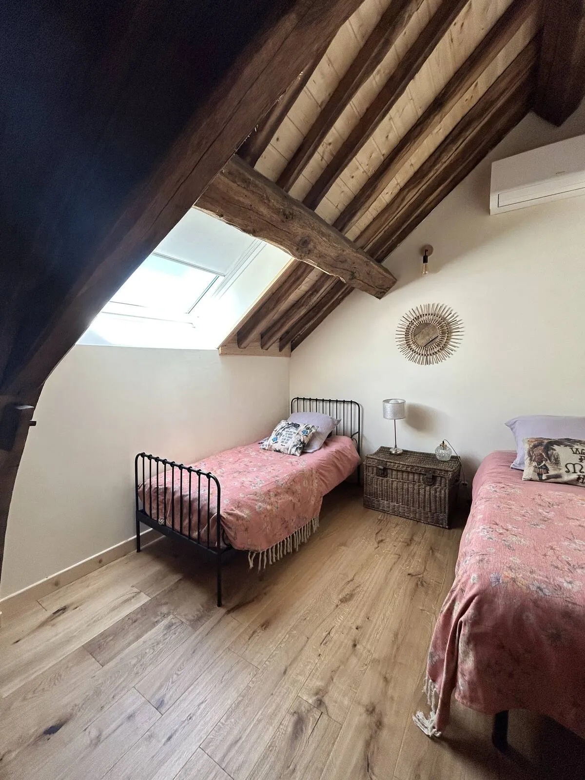 Small attic bedroom with a bed and skylight