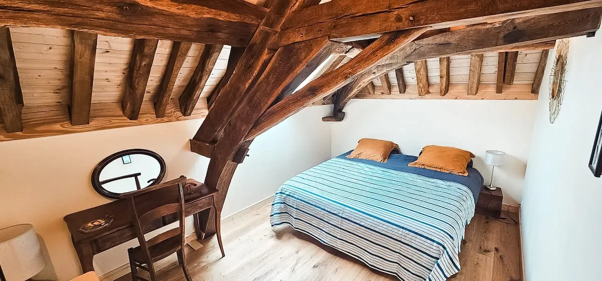 Master suite with exposed beams and a sitting area