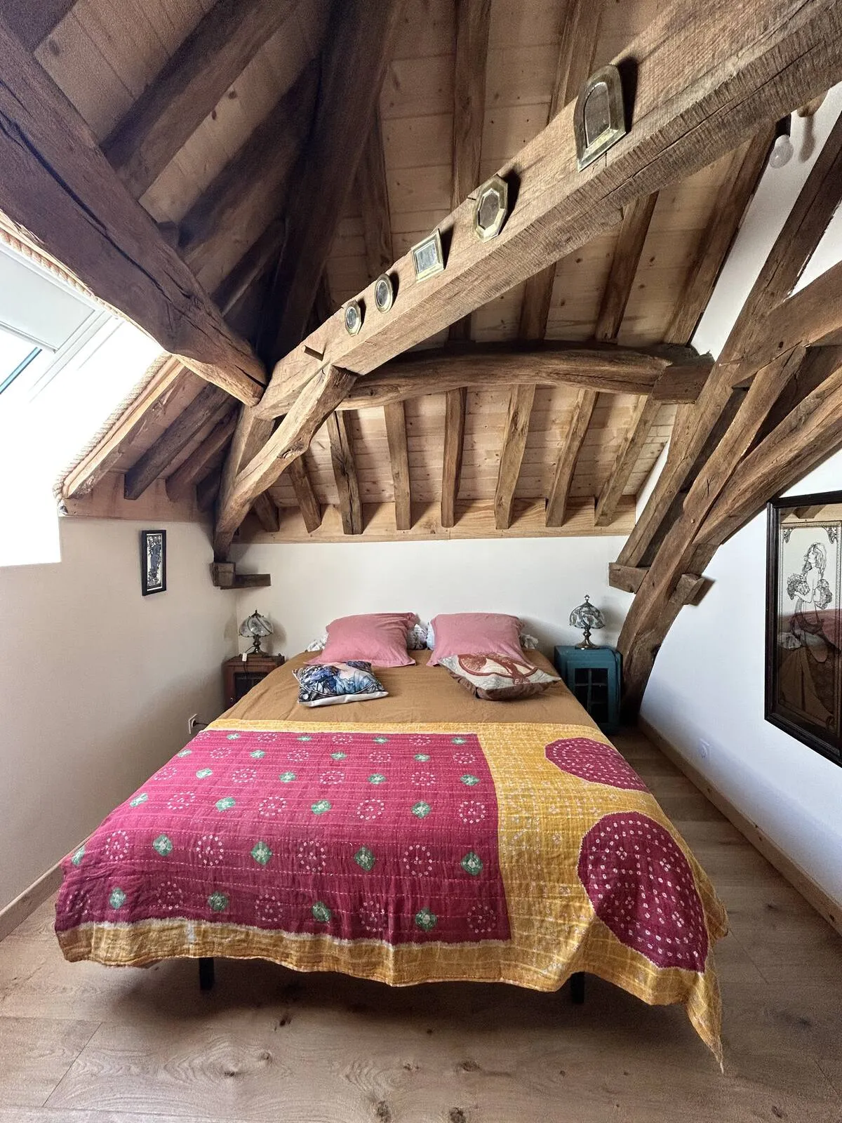 Attic bedroom with red bedspread and beams