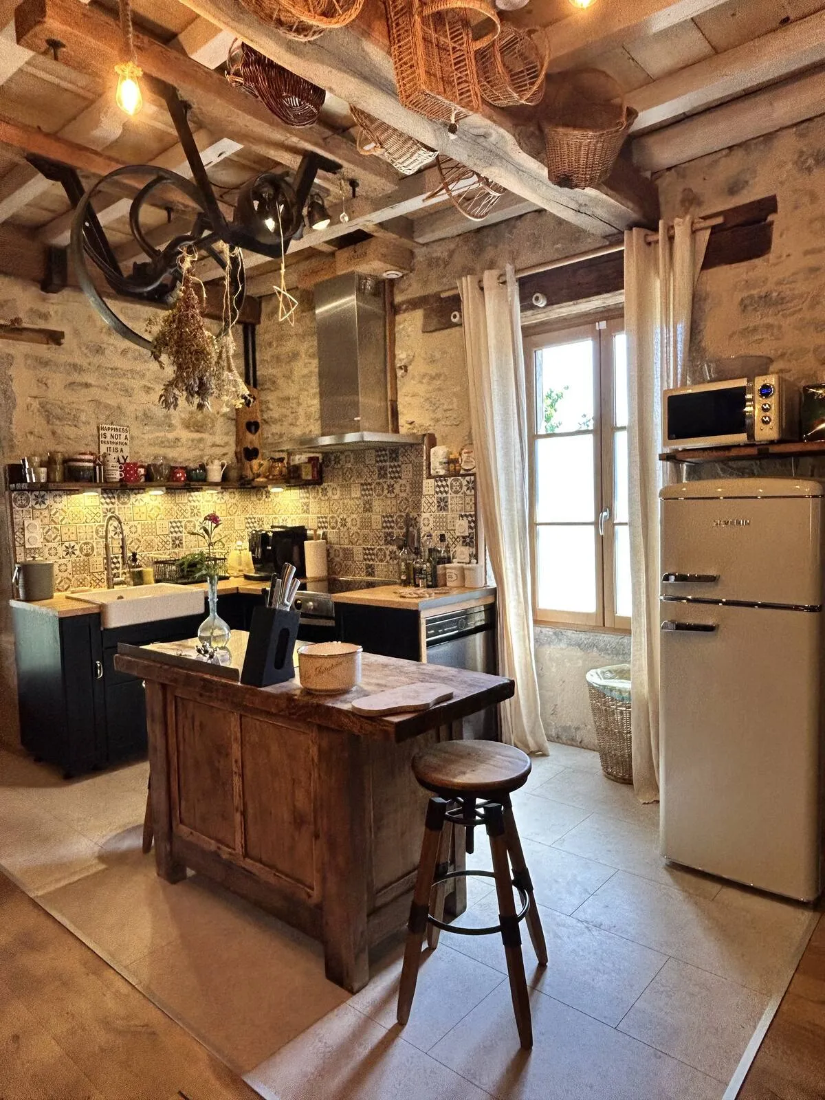 Kitchen with central island and stools, stone wall