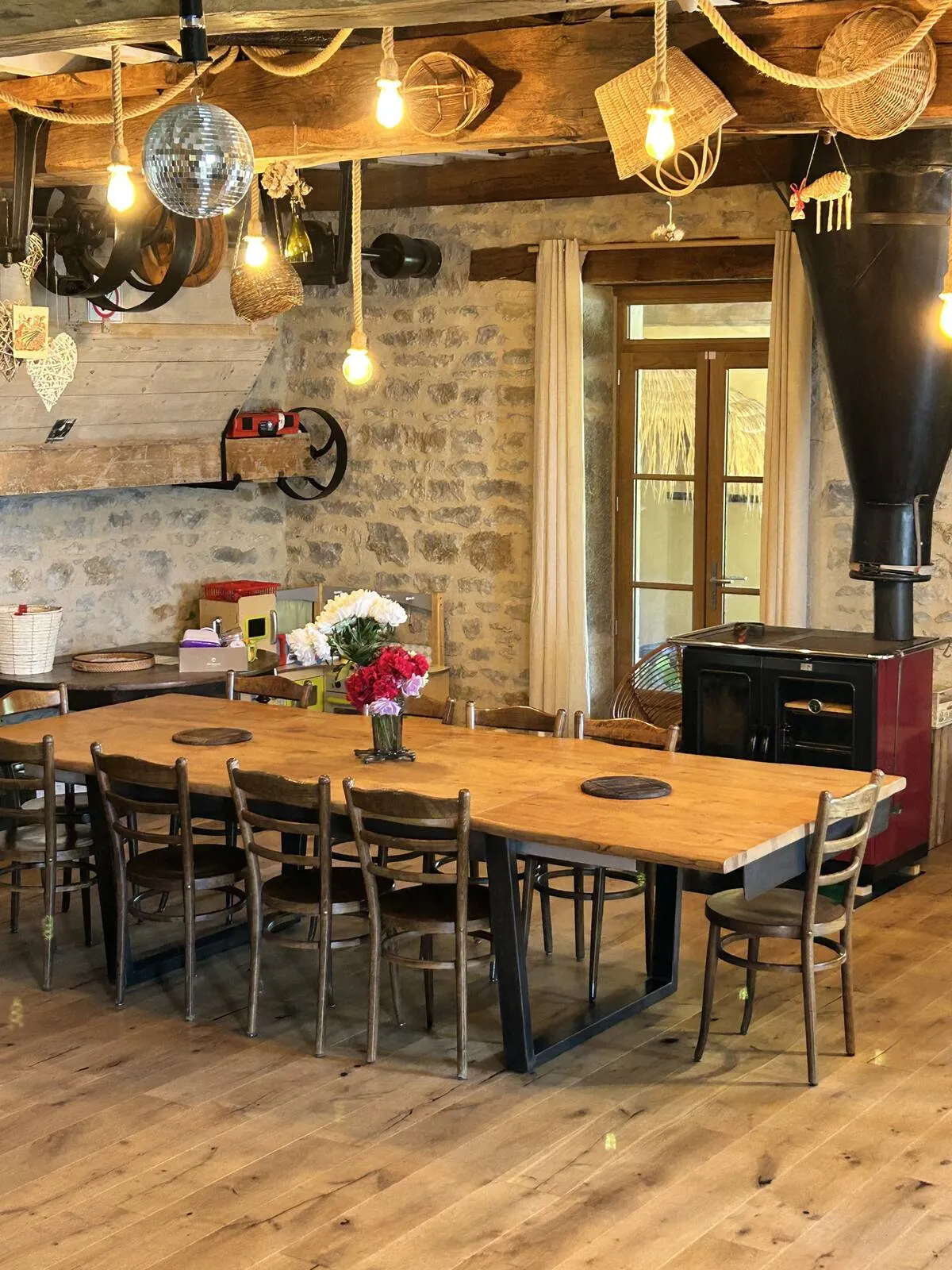 Dining room with long wooden table, beams and stone walls