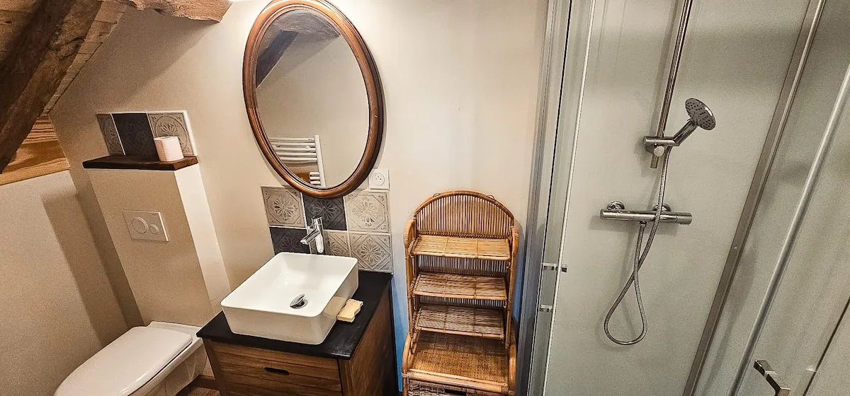 Bathroom with round mirror and shower