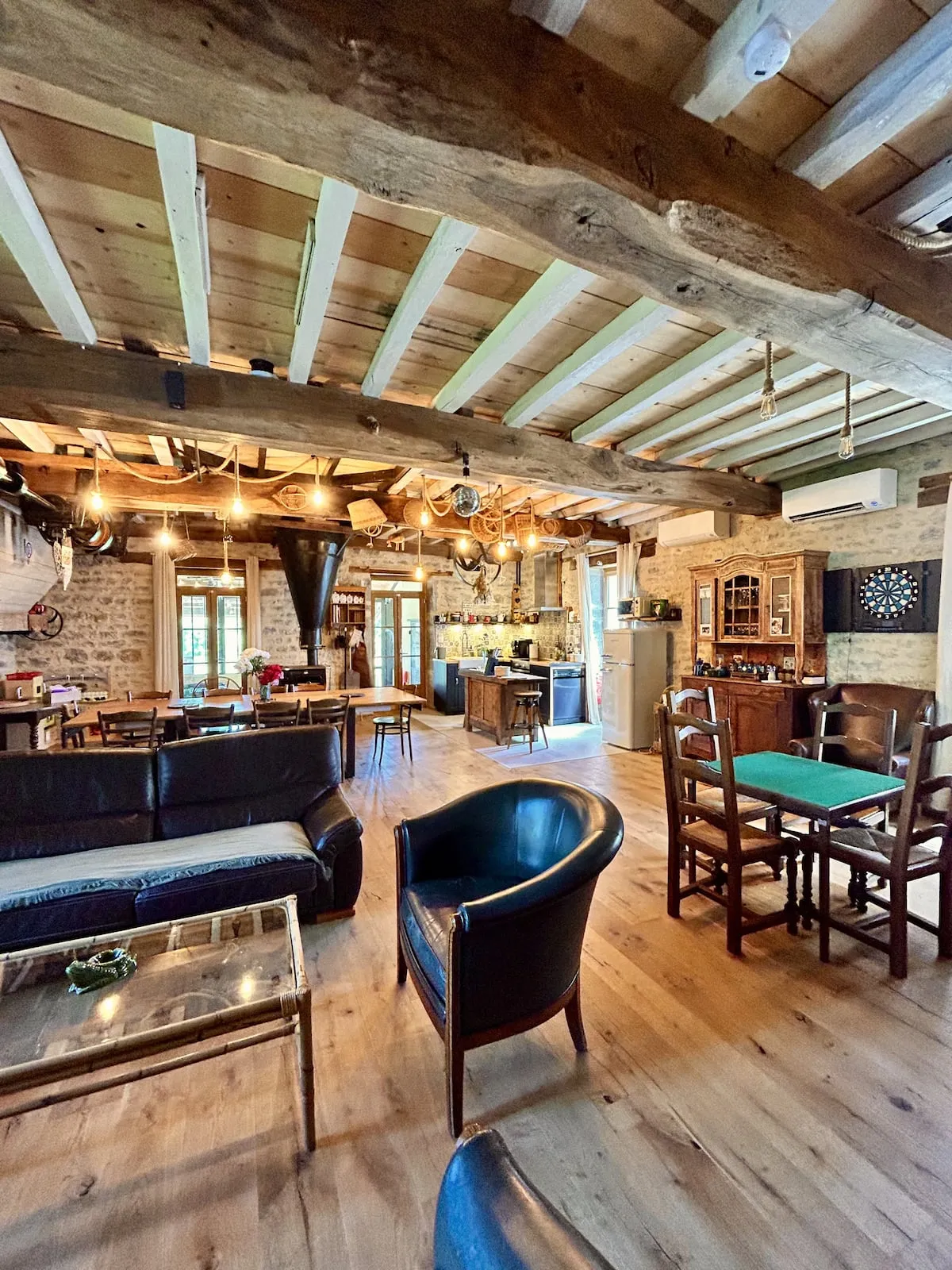 Lounge with leather sofas and open kitchen beneath the beams